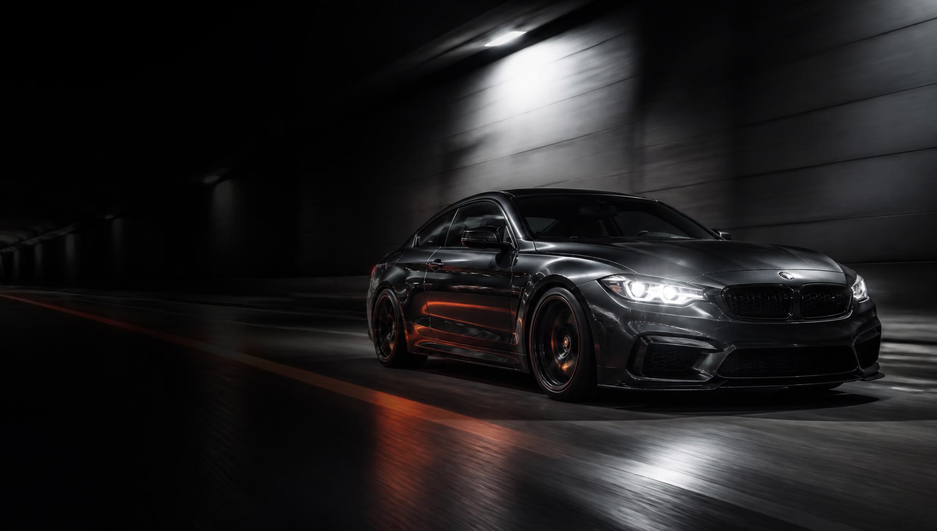 Graphite performance coupe accelerating through a night tunnel